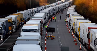 A long line of heavy trucks stuck in a traffic jam on a highway.