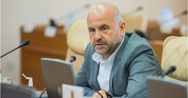 Vasile Bolea sitting at a table during a meeting.