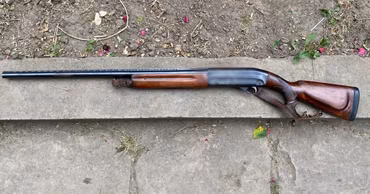 A hunting shotgun lying on a concrete surface, seized by police in Moldova.