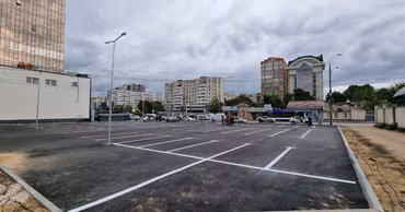 A newly paved parking lot with white markings in an urban area of Chisinau.
