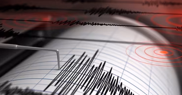 A close-up of a seismograph recording earthquake activity on paper.