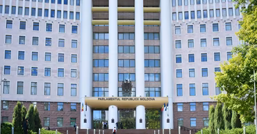 The Parliament building of the Republic of Moldova in Chisinau with a landscaped garden in front.