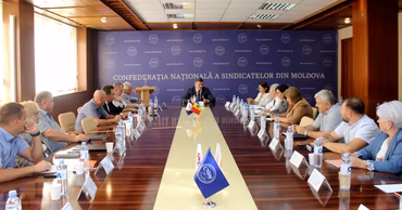 A meeting of the National Confederation of Trade Unions of Moldova (CNSM) in a conference room.