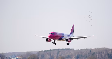 A Wizz Air passenger airplane landing at an airport.