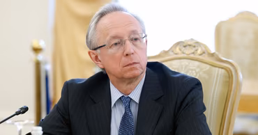 Mikhail Galuzin, Deputy Minister of Foreign Affairs of Russia, sitting at a table.