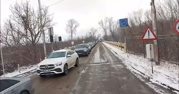 Cars waiting in a queue at a border crossing point in winter.