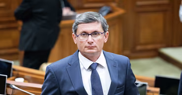 Sergiu Gurduza in a formal suit in a parliamentary setting.