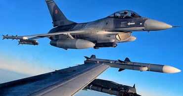 Two Romanian Air Force F-16 fighter jets flying in formation against a clear blue sky.