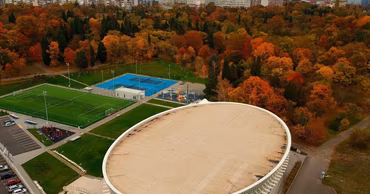Aerial view of Arena Burgas in Bulgaria with surrounding park and city skyline.
