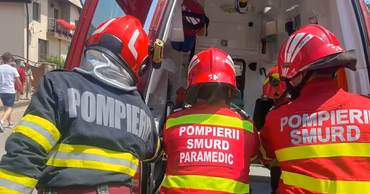 SMURD paramedics and firefighters working near an ambulance.
