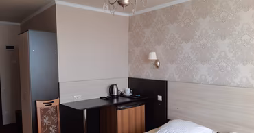 A hotel room interior with a bed, desk, and chair at the Zarya hotel in Chisinau.