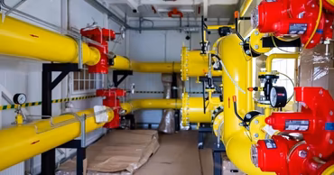 Industrial gas pipes and equipment inside a technical facility.