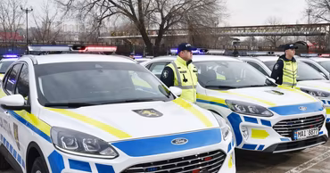 Moldovan police officers standing next to their patrol cars.