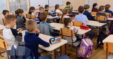 Children sitting at desks in a classroom during a lesson.