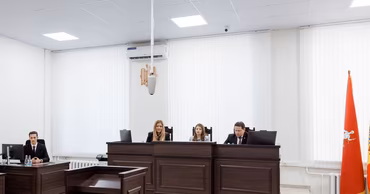 A courtroom in Moldova with judges and a clerk sitting at their desks.