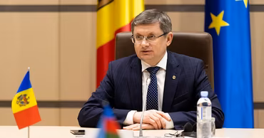 Igor Grosu, Speaker of the Parliament of Moldova, sitting at a desk with flags.