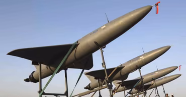 Several Shahed-136 kamikaze drones mounted on a mobile launcher platform.