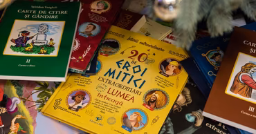 A collection of various children's books in Romanian language stacked together.