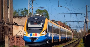 A modern passenger train of the Moldovan Railway traveling on tracks.