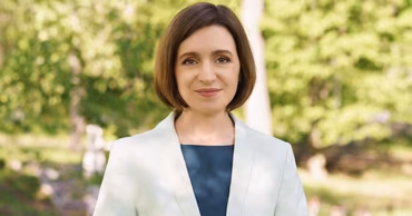 Portrait of Moldovan President Maia Sandu outdoors in a light blazer.