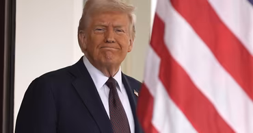 Donald Trump standing in front of an American flag.
