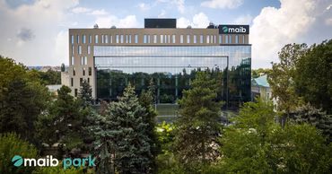 Aerial view of the maib park headquarters building in Chisinau surrounded by trees.