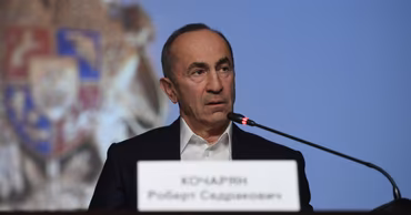 Robert Kocharyan sitting at a table with a nameplate in front of him.