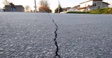 A crack in the asphalt road surface caused by an earthquake.