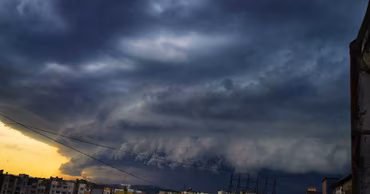 A dramatic view of dark, heavy storm clouds over a residential area in Moldova.