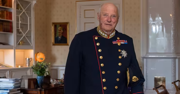 King Harald V of Norway in a formal military uniform standing in a room.