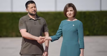 Volodymyr Zelensky and Maia Sandu shaking hands during an official meeting.