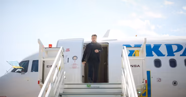 Volodymyr Zelenskyy descending the stairs of an airplane upon arrival.