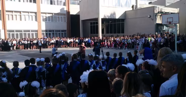 Students and parents gathered in a school courtyard for the first day of school ceremony.