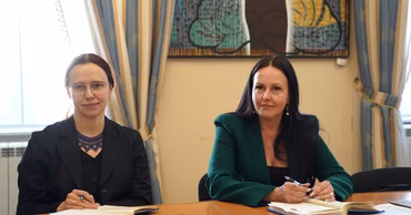 Two women sitting at a table during a meeting.