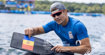 Moldovan canoeist Serghei Tarnovschi holding a paddle with the Moldovan flag.