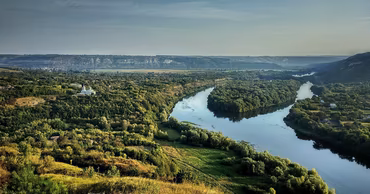 Aerial view of the Dniester river winding through a green landscape in Moldova.