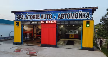 A car wash facility in Moldova with signs in Romanian and Russian.