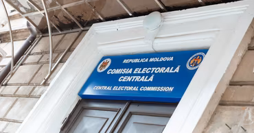 The sign of the Central Electoral Commission of Moldova on a building facade.