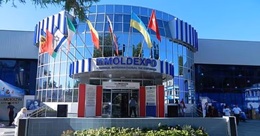 The main entrance of the Moldexpo exhibition center in Chisinau with flags displayed.