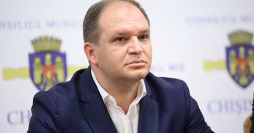 Portrait of Ion Ceban, Mayor of Chisinau, in front of a municipal backdrop.