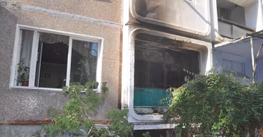 A residential building facade with a fire-damaged balcony in Balti.