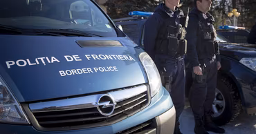 Moldovan border police officers standing next to a patrol vehicle.