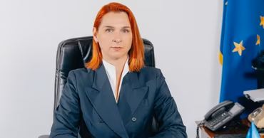 Portrait of Anna Revenco sitting at an office desk.