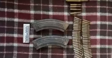 Seized ammunition and firearm magazines laid out on a plaid blanket.