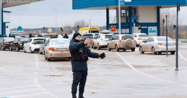 A Moldovan border police officer directing traffic at a border crossing point.