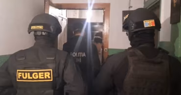 Moldovan Fulger special police unit officers entering a building during an investigation.