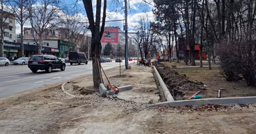 Construction workers repairing sidewalks and curbs on a street in Chisinau.