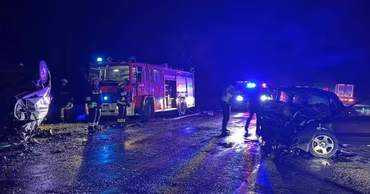 Emergency vehicles and responders at the scene of a night road accident.