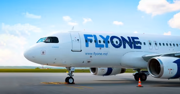 A FlyOne passenger airplane parked on the tarmac at an airport.
