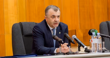 Ion Chicu speaking at a press conference behind a desk with microphones.